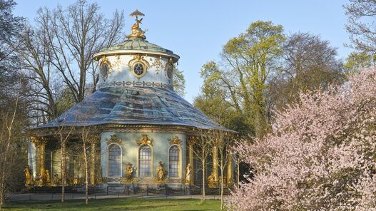 Das Chinesische Haus im Frühling, im Vordergrund blühende Sträucher 