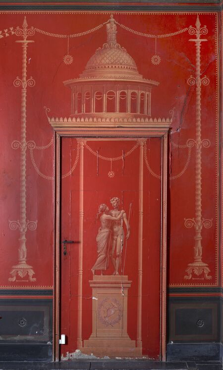 Blick auf eine rote Wand mit dem Tor zur Vorhalle des Viridariums im Atrium der Römischen Bäder im Park Sanssouci 
