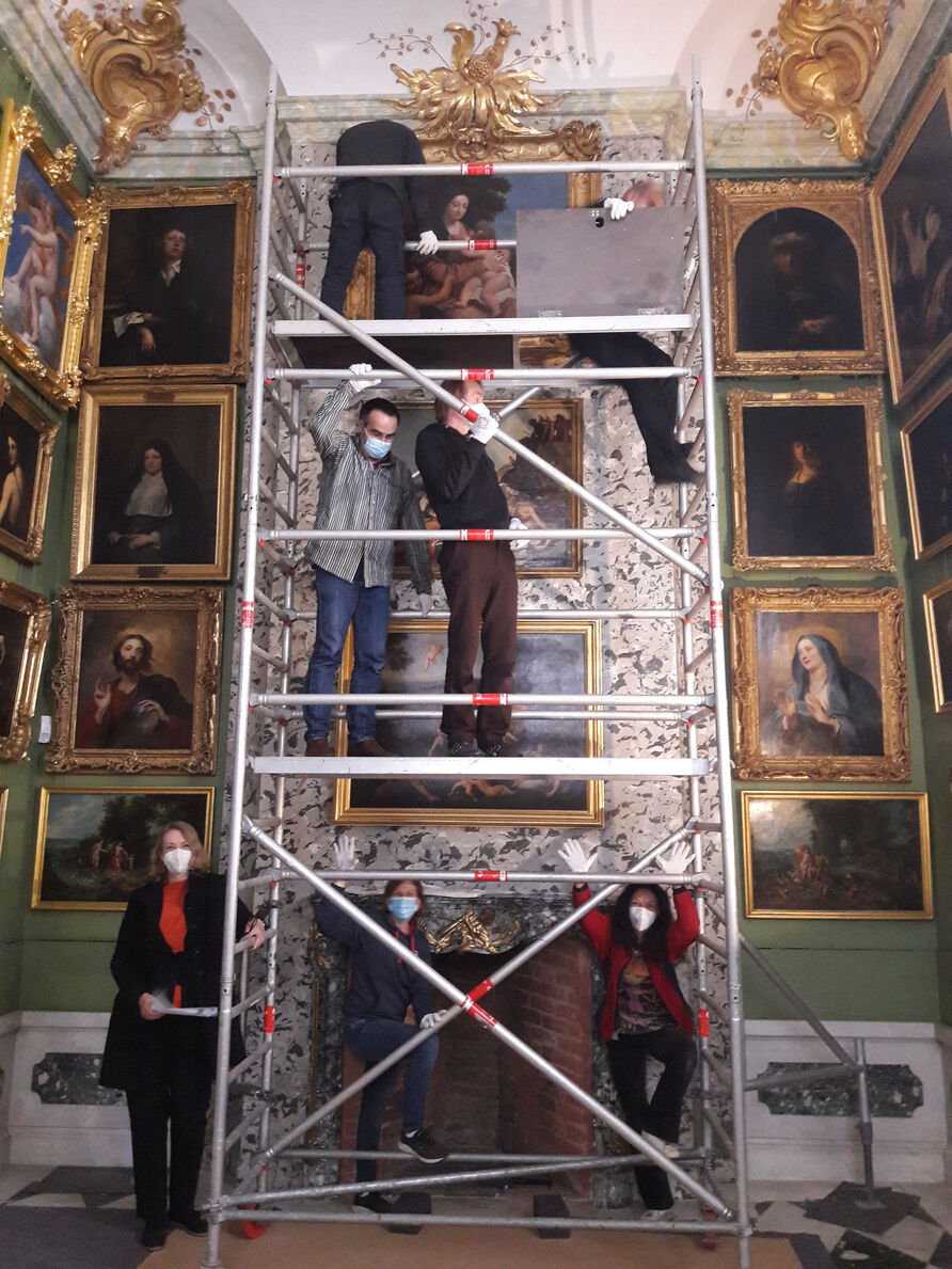 Sieben Personen und ein spezielles Gerüst wurden benötigt, um die Madonna wieder im Kabinett der Gemäldegalerie an die Wand zu bringen. Unten links: Dr. Alexandra Bauer, Kustodin für Gemälde deutscher und niederländischer Schulen © SPSG