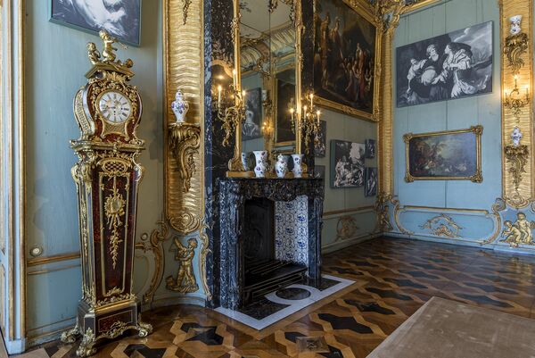 Blick in die Blaue Kammer er Königswohnung mit einem Kamin und Gemälden 