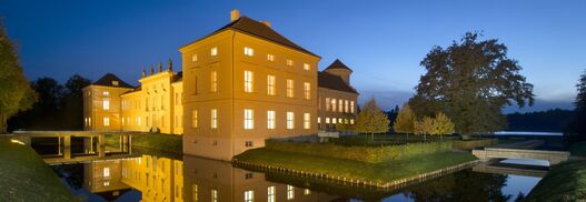 Schloss Rheinsberg in der Dämmerung mit hell erleuchteten Fenstern