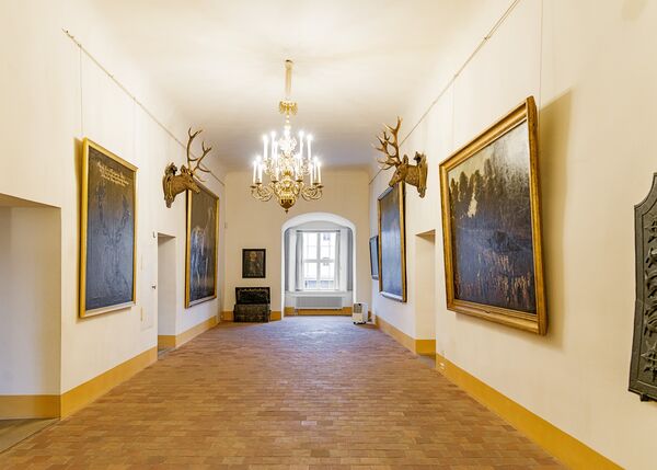 Flur mit Gemälden und Geweih an der Wand im Schloss Königswusterhausen 