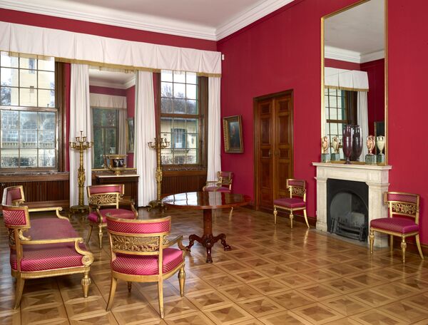 Roter Saal im Schloss Glienicke mit Stühlen, Tischen und Kamin