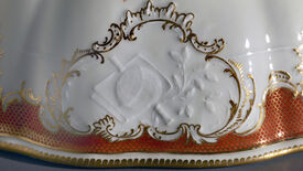 Meißen: Wärmeglocke aus dem Service Friedrichs II. mit preußisch-musikalischem Dessin (rot), Symbol der Künste und Wissenschaften, 1761 © SPSG / Wolfgang Pfauder Eine Wärmeglocke für den Frieden: Tafelkultur und Politik