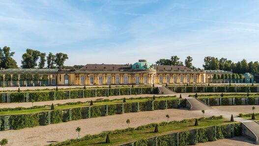 Blick auf das Schloss Sanssouci im Sonnenschein, im Vordergrund die Terrassen