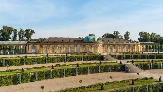 Blick auf das Schloss Sanssouci im Sonnenschein, im Vordergrund die Terrassen