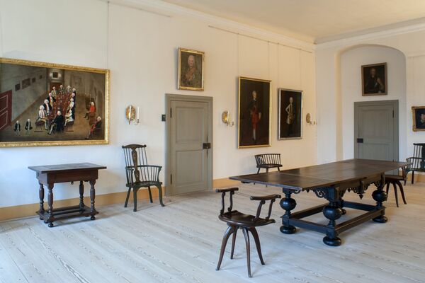 Tabakskollegium im Schloss Königs Wusterhausen © SPSG / Günter Schneider Blick in das Tabakskollegium im Schloss Königswusterhausen mit großen Tisch, Stühlen, Gemälden