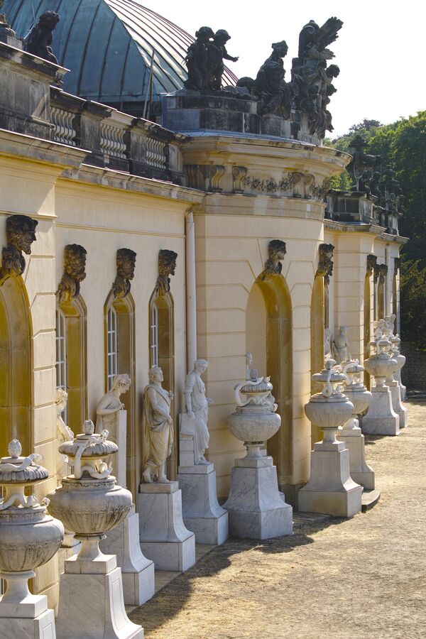 Seitlicher Blick auf eine Skulpturenreihe an der Gartenfassade der Bildergalerie im Park Sanssouci