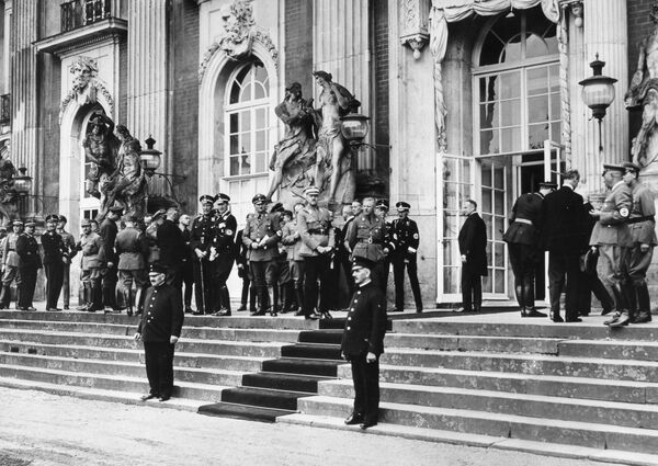Members of the Prussian State Council assembled in front of the New Palace during a session break, 16 September 1933. Standing in front of the left windowed door: SA leader Ernst Röhm (left) and Reichsführer of the SS Heinrich Himmler; in front of the centre windowed door: SS group leader Udo von Woyrsch and Josias Erbprinz von Waldeck und Pyrmont; next to the right windowed door (with his back to the camera): Wilhelm Furtwängler, principal conductor of the Berlin State Opera