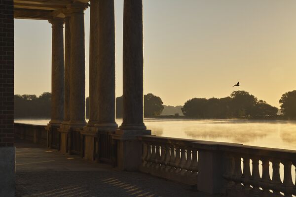 Blick bei Sonnenuntergang durch den Säulengang des Marmorpalais auf den Heiligen See