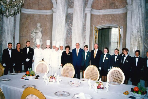 Abschlussfoto mit Bundeskanzler Helmut Kohl und US-Präsident Bill Clinton sowie Mitarbeiter:innen des Schlosshotels Cecilienhof. Das Essen wurde im Schlosshotel zubereitet und nach Sanssouci transportiert.