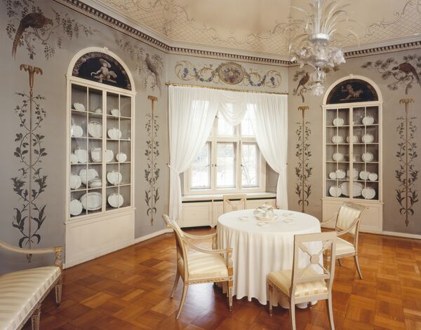 Blick in das Frühstückszimmer im Schloss Cecilienhof mit Tisch und Porzellan in den Schränke