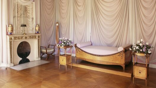 Schlafzimmer der Königin Luise im Neuen Flügel mit Bett, Kamin und drapierten Vorhängen an den Wänden